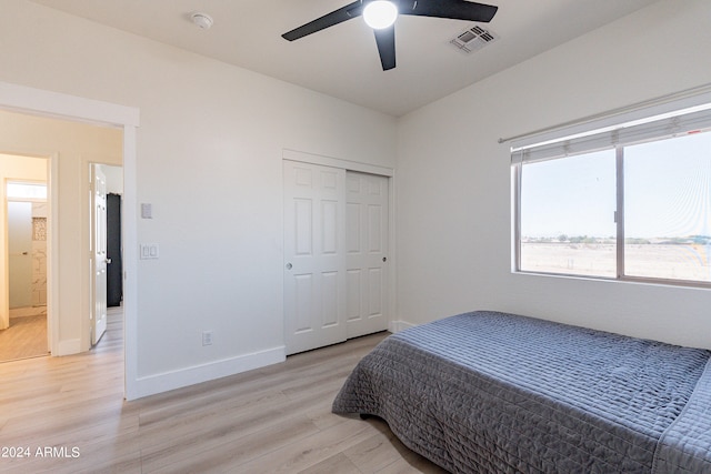 bedroom with ceiling fan, light hardwood / wood-style flooring, and a closet