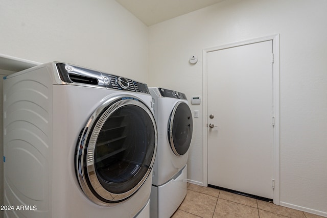 laundry area featuring separate washer and dryer and light tile patterned floors