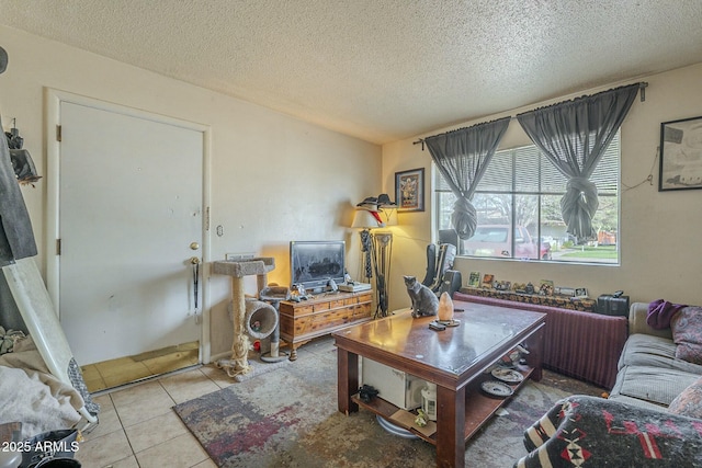 living area with tile patterned flooring and a textured ceiling