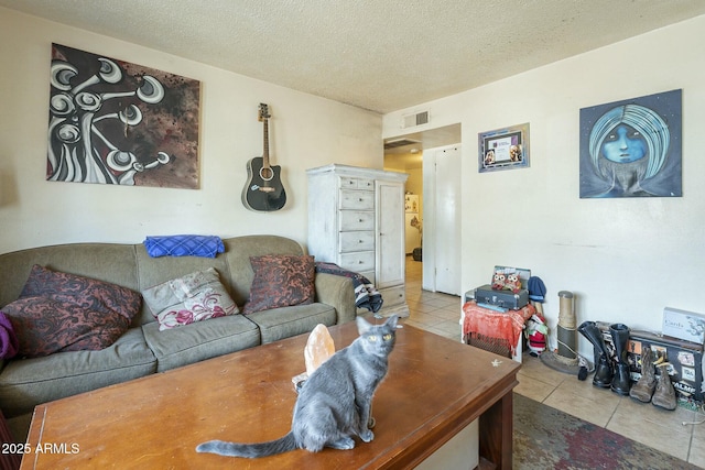 living area with a textured ceiling, tile patterned flooring, and visible vents