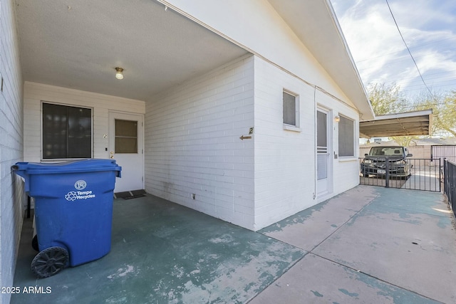 view of home's exterior featuring concrete block siding, a patio, and fence