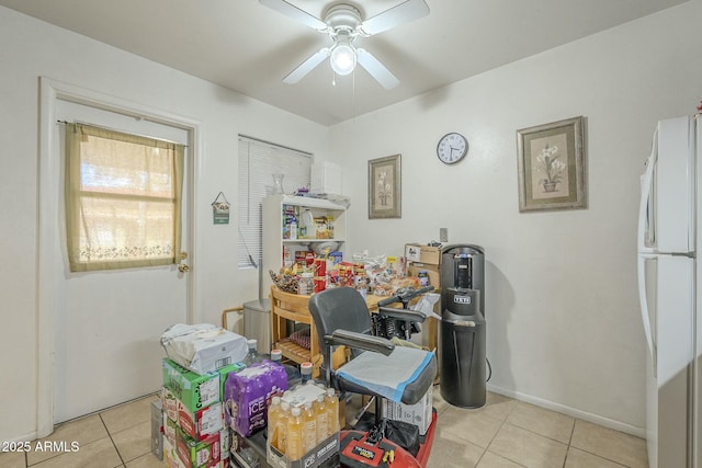 office space with a ceiling fan, baseboards, and light tile patterned floors