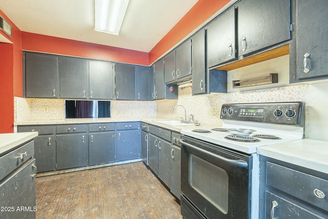 kitchen featuring tasteful backsplash, electric range oven, dark wood-style floors, light countertops, and a sink