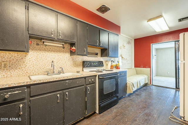 kitchen with electric range, tasteful backsplash, visible vents, dark wood-style floors, and a sink