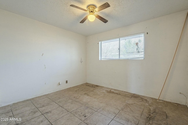 empty room with ceiling fan and a textured ceiling