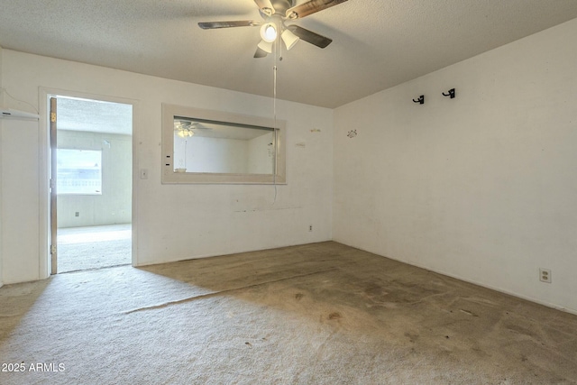 empty room featuring a textured ceiling, ceiling fan, and carpet