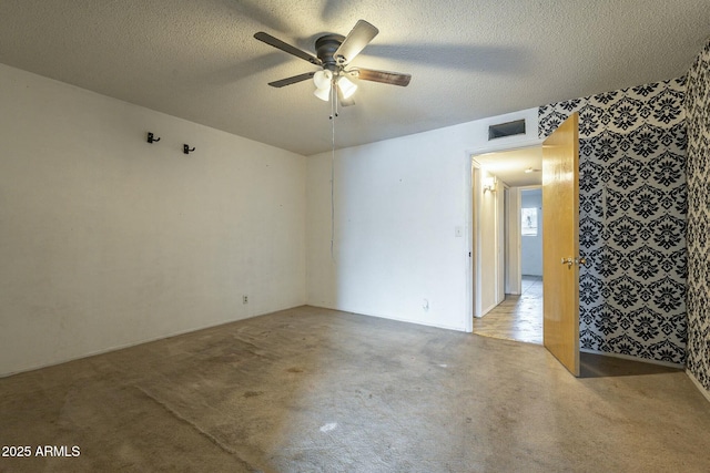 unfurnished room featuring light carpet, ceiling fan, a textured ceiling, and visible vents