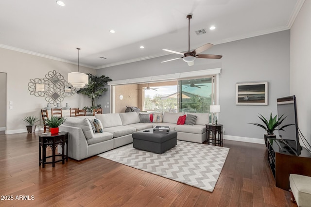 living room featuring dark wood-type flooring, crown molding, a ceiling fan, and visible vents