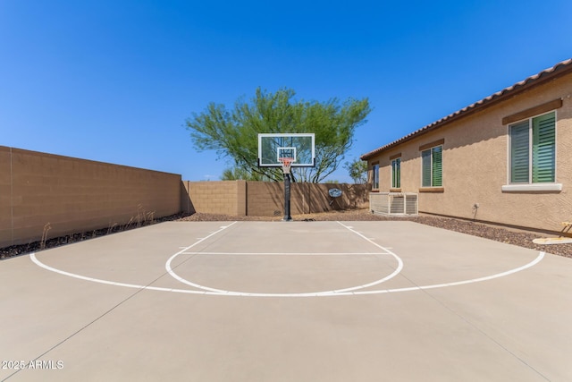 view of basketball court with basketball court and a fenced backyard