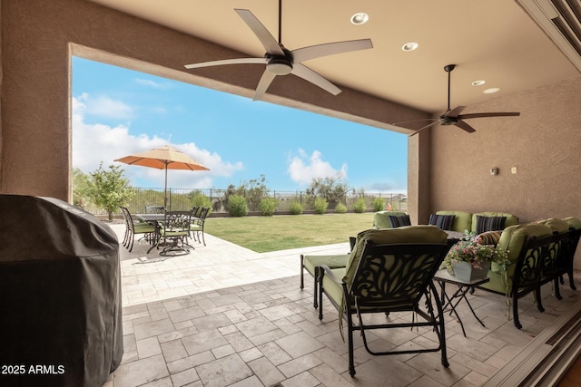 view of patio featuring outdoor dining space, fence, area for grilling, and a ceiling fan