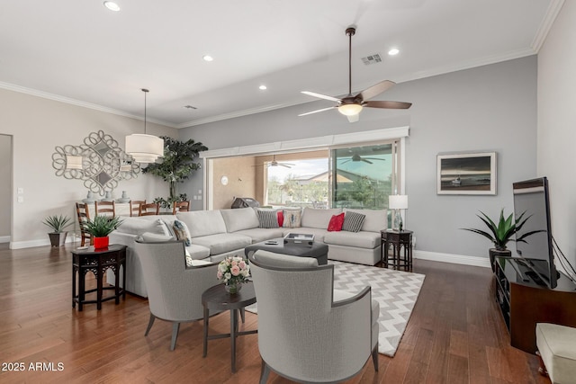 living room with a ceiling fan, ornamental molding, dark wood finished floors, and visible vents