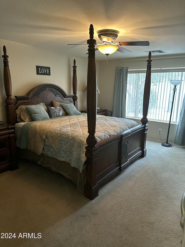 bedroom featuring a textured ceiling, carpet floors, and ceiling fan