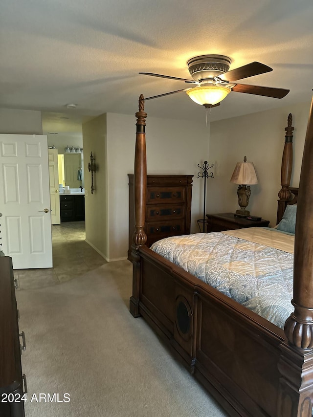 carpeted bedroom featuring ceiling fan and ensuite bathroom