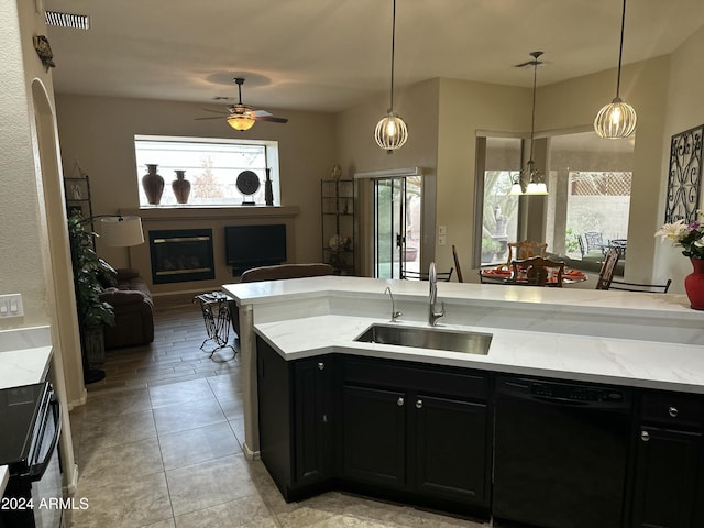 kitchen featuring light stone countertops, dishwasher, a healthy amount of sunlight, and sink