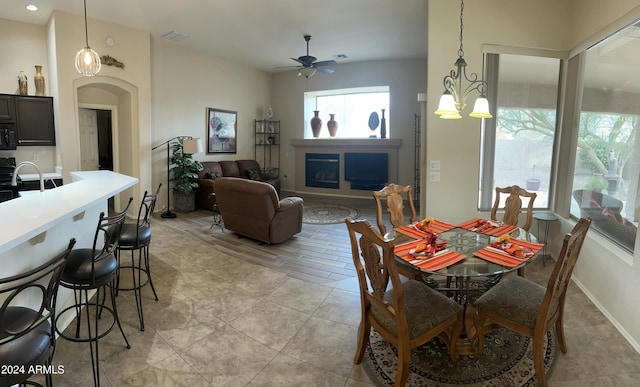 dining area with light wood-type flooring and ceiling fan with notable chandelier