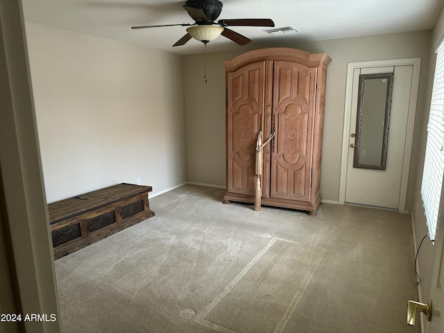 unfurnished bedroom with ceiling fan and light carpet