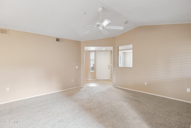 unfurnished room featuring ceiling fan, light colored carpet, visible vents, lofted ceiling, and baseboards