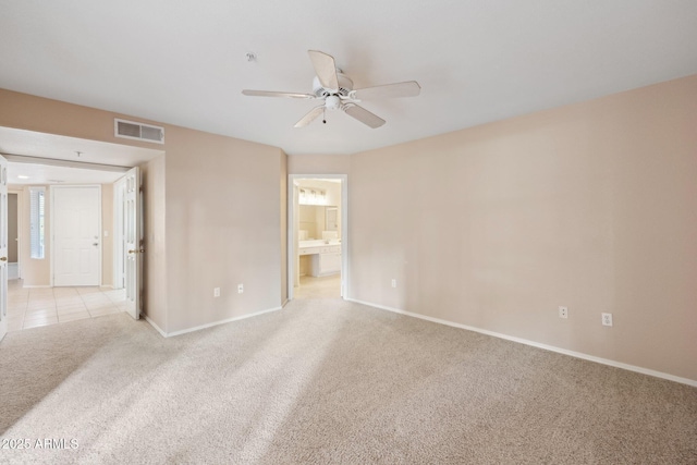 unfurnished bedroom featuring baseboards, a ceiling fan, connected bathroom, visible vents, and light colored carpet