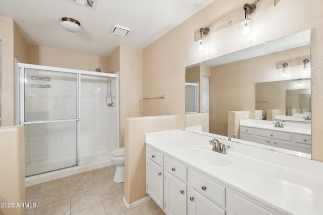 bathroom featuring a shower stall, vanity, tile patterned flooring, and toilet