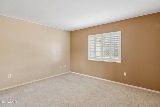 carpeted spare room featuring baseboards