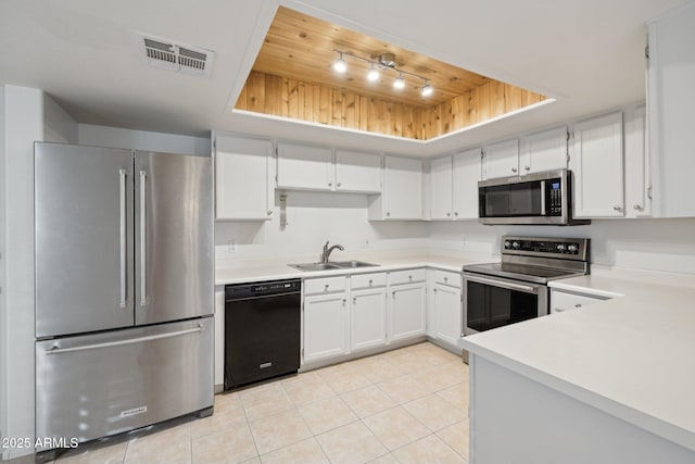 kitchen with visible vents, a sink, wood ceiling, a tray ceiling, and stainless steel appliances