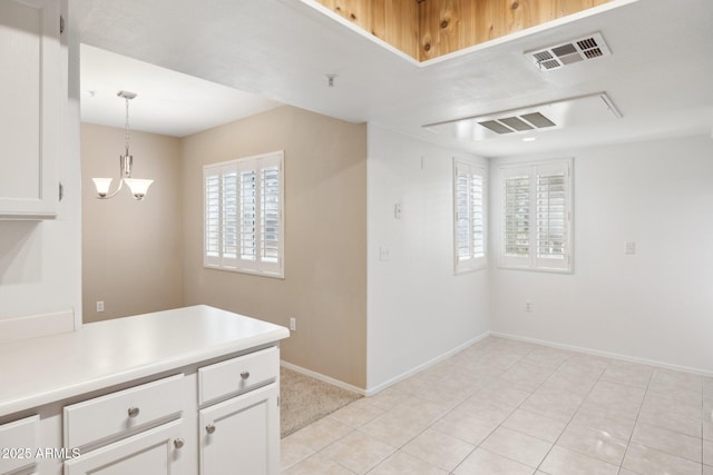 kitchen with white cabinets, light countertops, visible vents, and hanging light fixtures