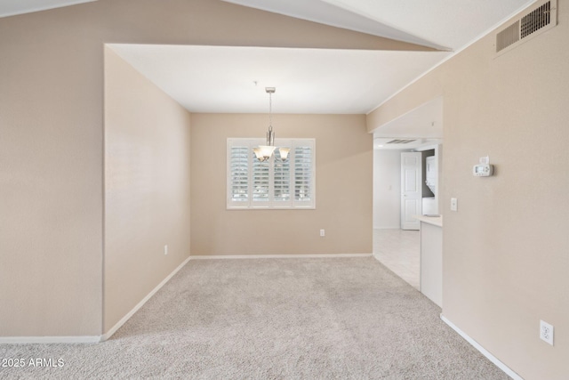 empty room with vaulted ceiling, visible vents, a chandelier, carpet floors, and baseboards