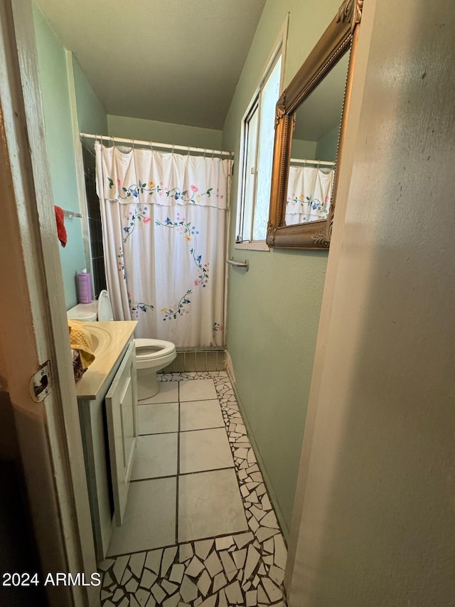 bathroom featuring vanity, toilet, walk in shower, and tile patterned flooring