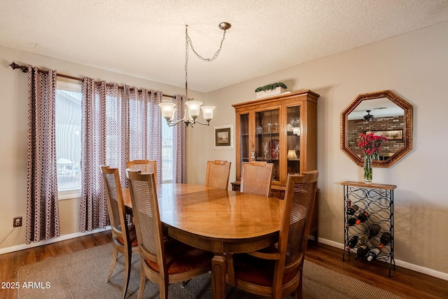 dining space featuring an inviting chandelier, dark hardwood / wood-style floors, and a textured ceiling