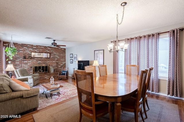 dining area with a healthy amount of sunlight, a textured ceiling, and a fireplace