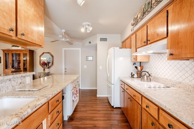 kitchen with white appliances, ceiling fan, dark hardwood / wood-style floors, light stone countertops, and decorative backsplash