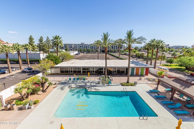 community pool featuring fence and a patio