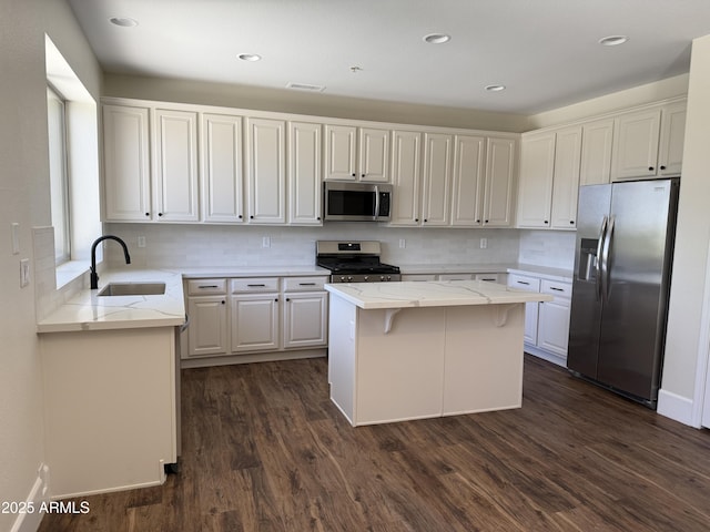 33220 N 60th Way, Scottsdale, AZ 85266 - kitchen with appliances with stainless steel finishes, light stone countertops, dark wood finished floors, a center island, and backsplash