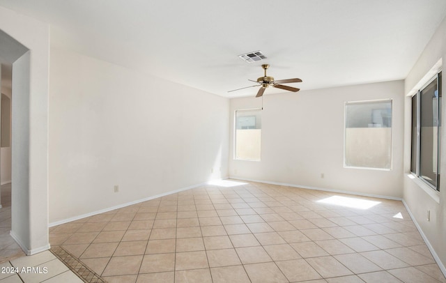 tiled spare room with ceiling fan