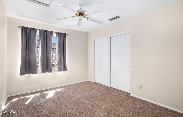 unfurnished bedroom with ceiling fan, a closet, and carpet flooring