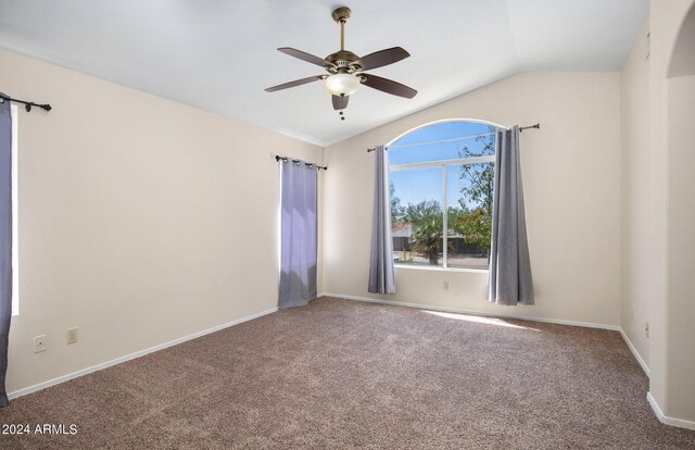 empty room featuring carpet, vaulted ceiling, and ceiling fan