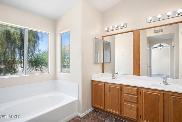 bathroom with ceiling fan, vanity, and a tub