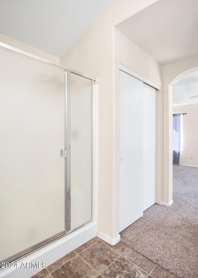 bathroom with an enclosed shower and tile patterned floors