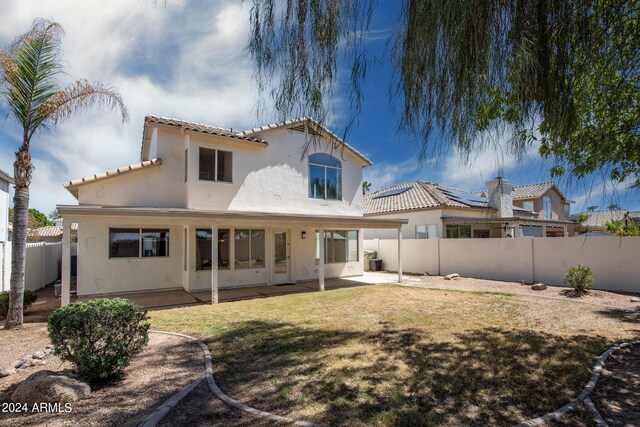 rear view of property with a lawn and a patio area