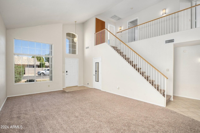 interior space with high vaulted ceiling and light carpet