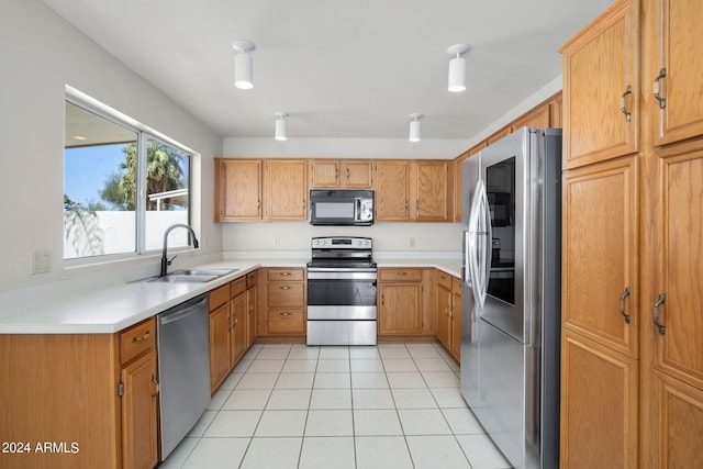 kitchen with appliances with stainless steel finishes, light tile patterned floors, and sink