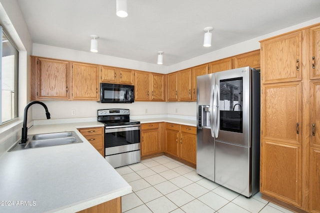 kitchen featuring stainless steel appliances, light tile patterned floors, and sink