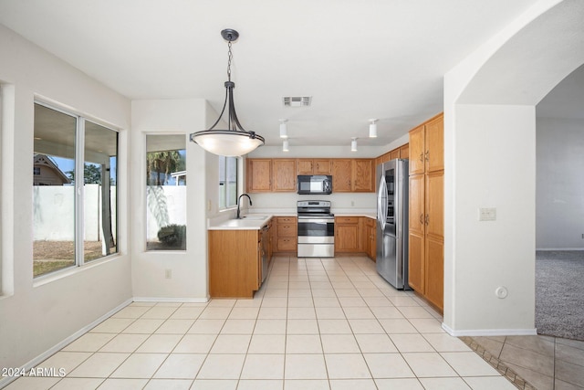 kitchen with pendant lighting, appliances with stainless steel finishes, light tile patterned floors, and sink