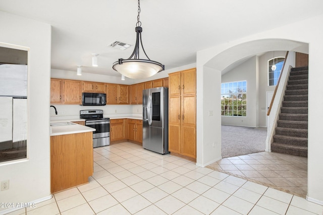 kitchen with light tile patterned floors, decorative light fixtures, stainless steel appliances, and sink