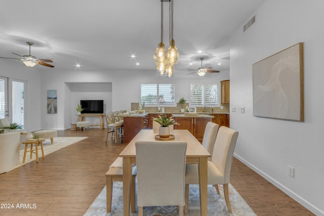 dining area featuring light hardwood / wood-style floors, sink, and ceiling fan