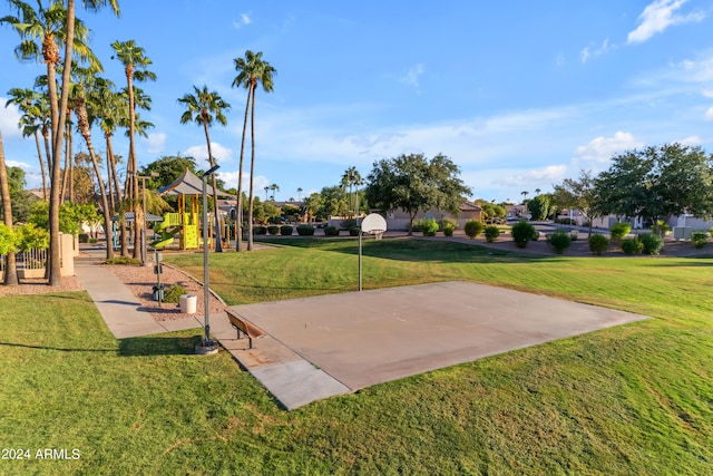 view of community featuring a playground, basketball hoop, and a lawn