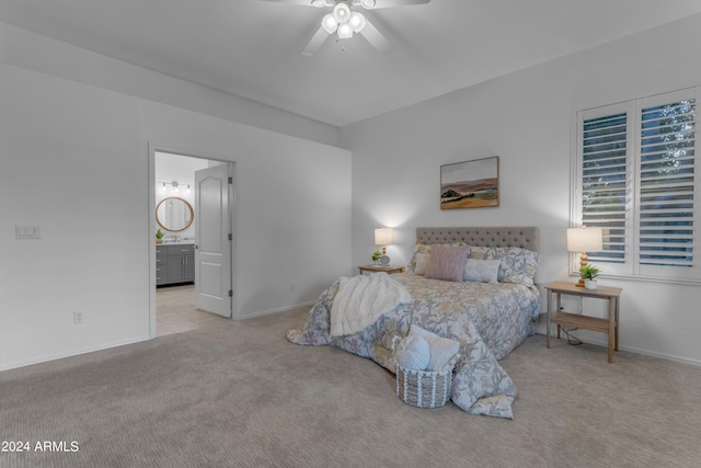 bedroom with ceiling fan, ensuite bath, and light carpet