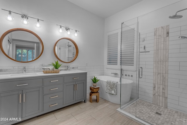 bathroom featuring tile walls, vanity, and shower with separate bathtub