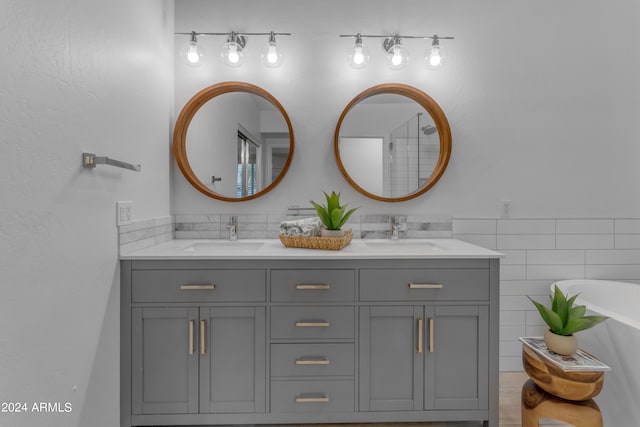 bathroom featuring a bathtub, vanity, and tile walls