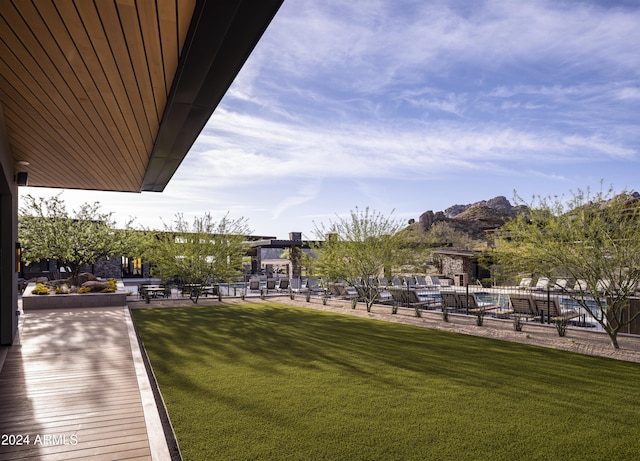 surrounding community with a mountain view and a lawn